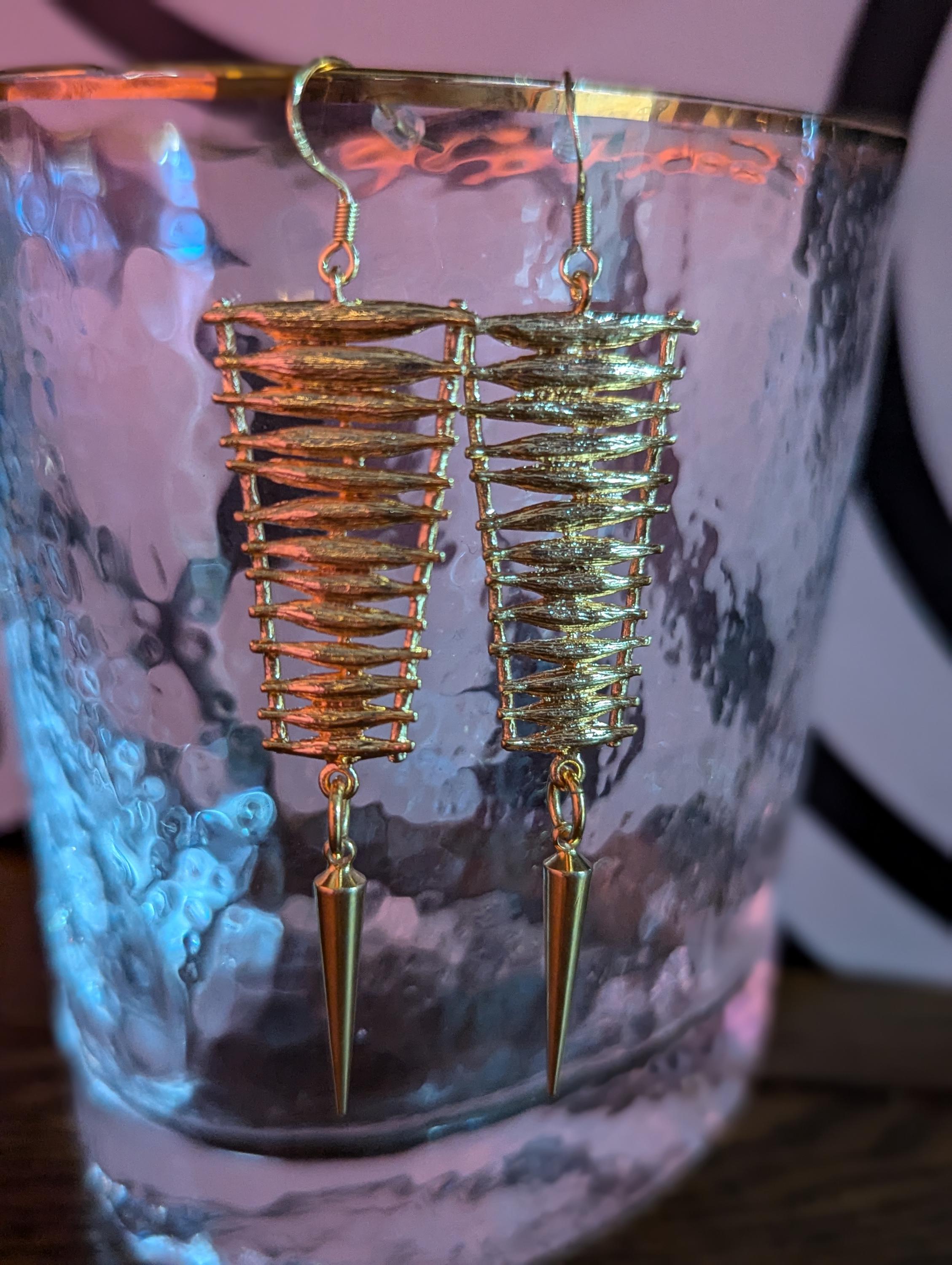 Gold ladder earring with gold spike dangle.